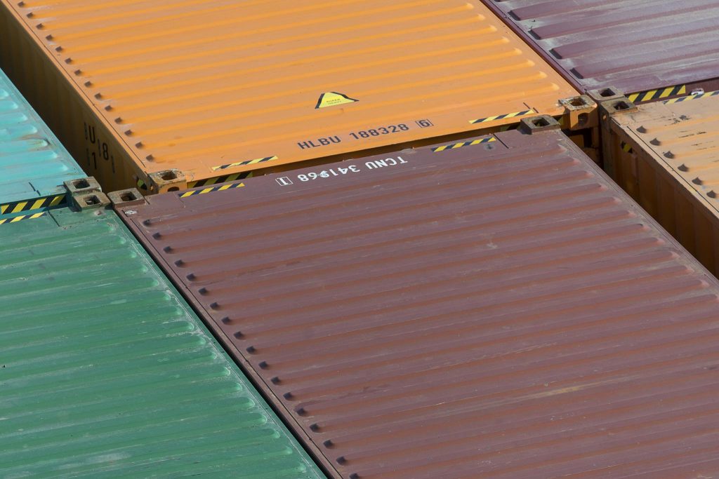 Aerial view of vibrant cargo containers arranged in a pattern, emphasizing logistics and transportation.