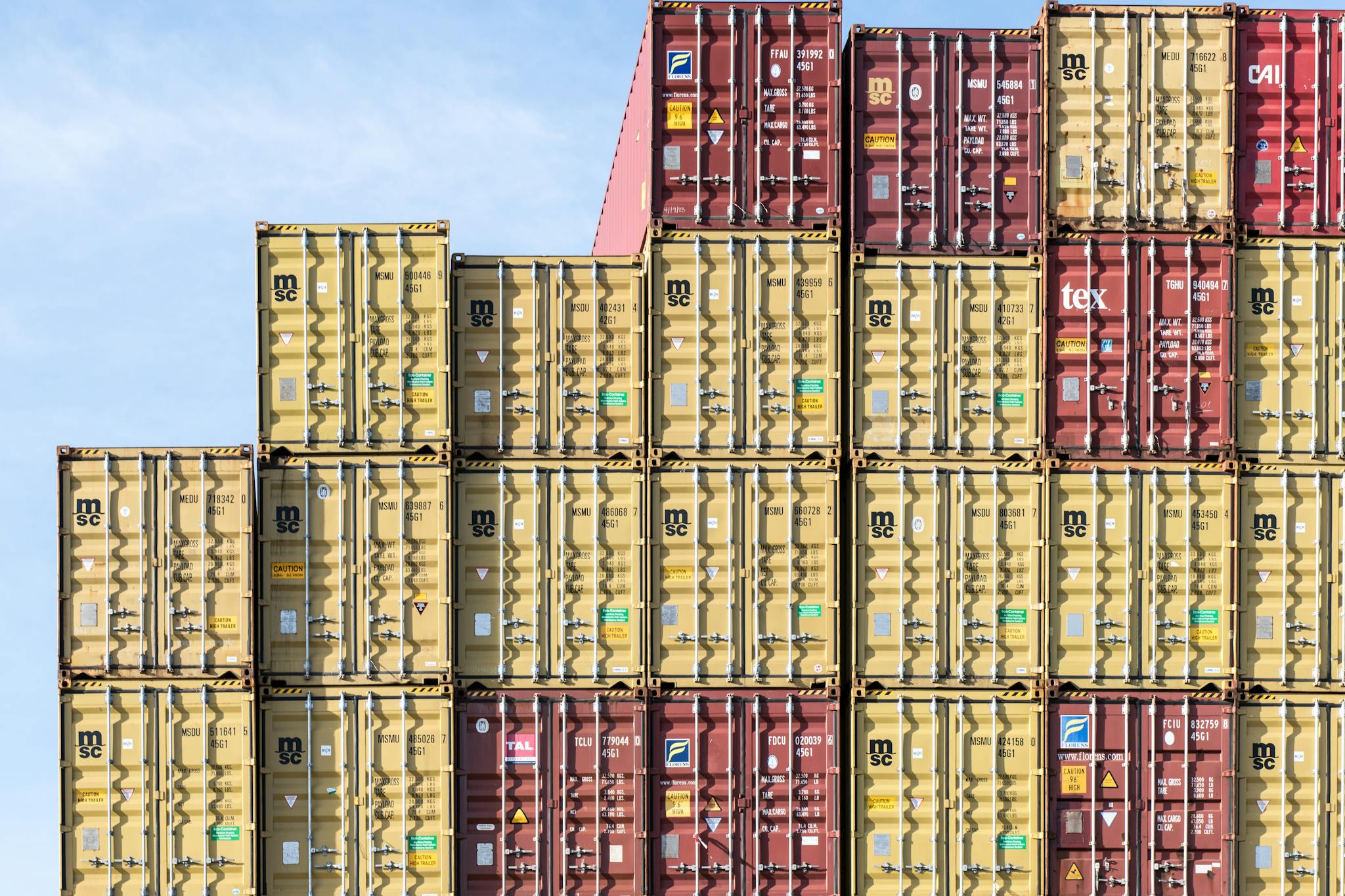 Colorful stacked shipping containers at Hamburg port, showcasing global trade and logistics.